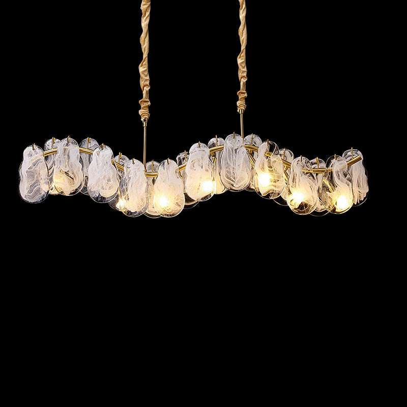 Illuminated 39-inch modern linear chandelier with layered white-swirled glass forms and visible lights along a curved gold frame against a black background.