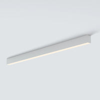 A modern linear LED ceiling light fixture in a sleek rectangular white housing, shown mounted on a plain light gray ceiling.