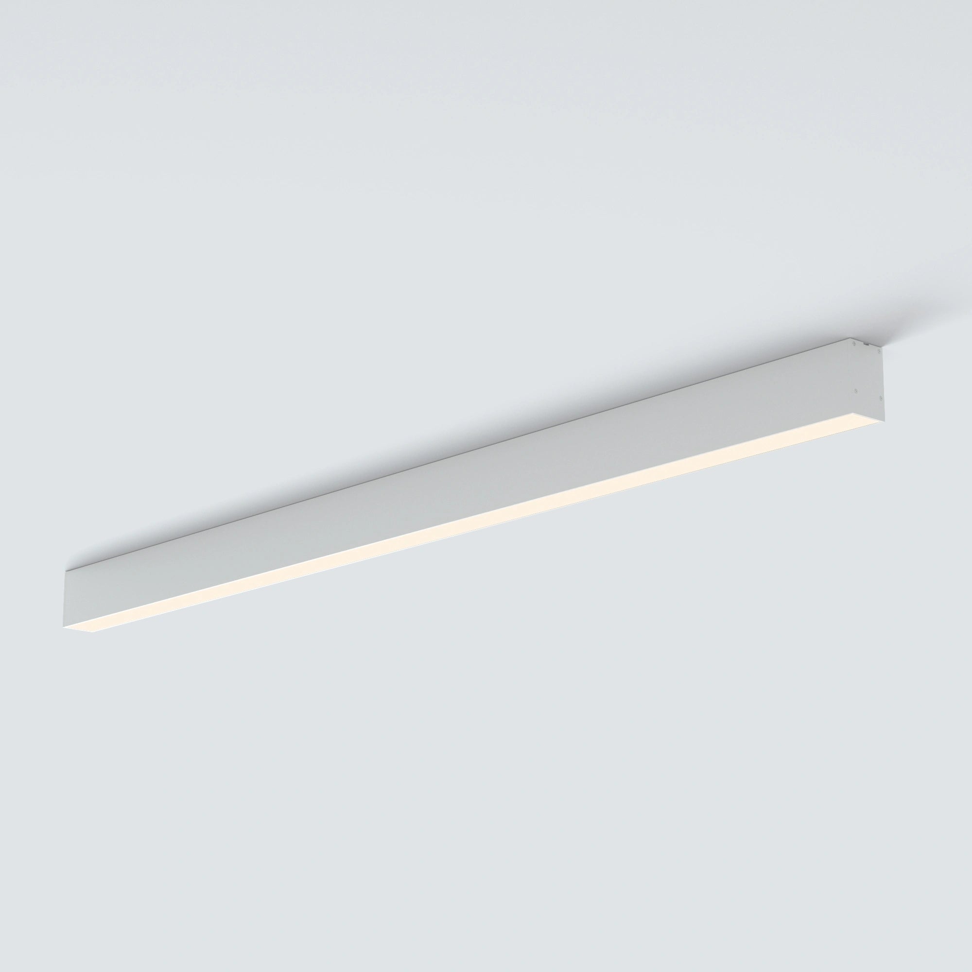 A modern linear LED ceiling light fixture in a sleek rectangular white housing, shown mounted on a plain light gray ceiling.