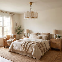 WOMO WM2391 round alabaster chandelier with vertical panels above a bed in a bright, neutral bedroom.