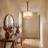 WOMO WM2391 illuminated alabaster chandelier in a narrow entryway above a wood console with dried flowers.