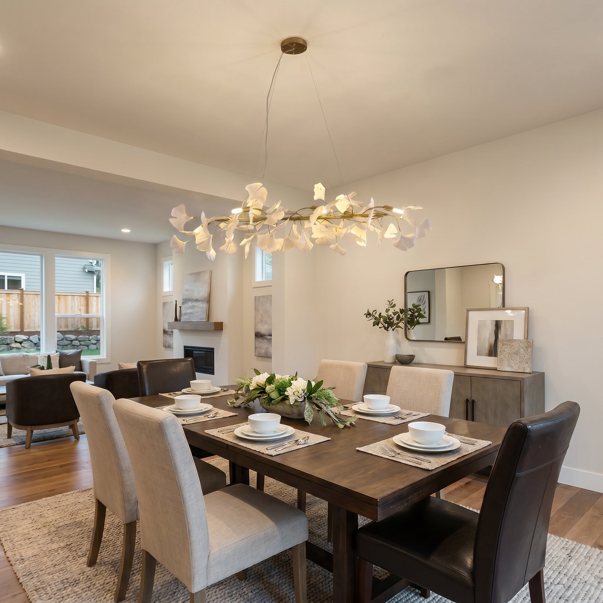 Linear ceramic leaf chandelier lighting an open dining area with upholstered chairs.