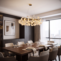 Round ceramic leaf chandelier centered over a dark wood table in a modern dining room.