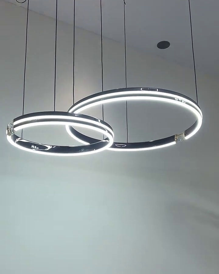 Cool-light mode sharpens the suspended rings, giving the modern chandelier a crisp and focused architectural presence.
